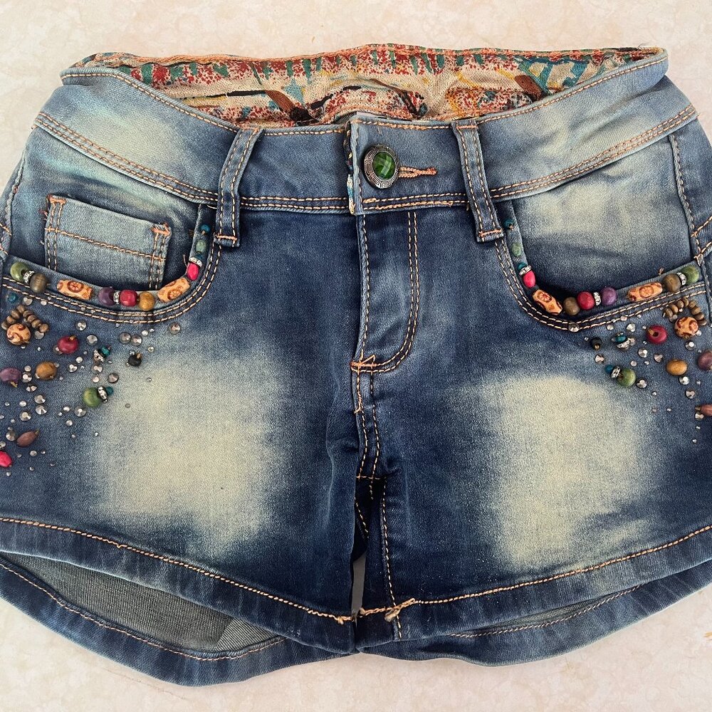 Distressed jean short with wood beading and silver studs.